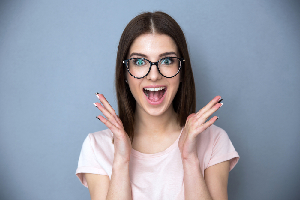 Surprised,Young,Woman,In,Glasses,Over,Gray,Background